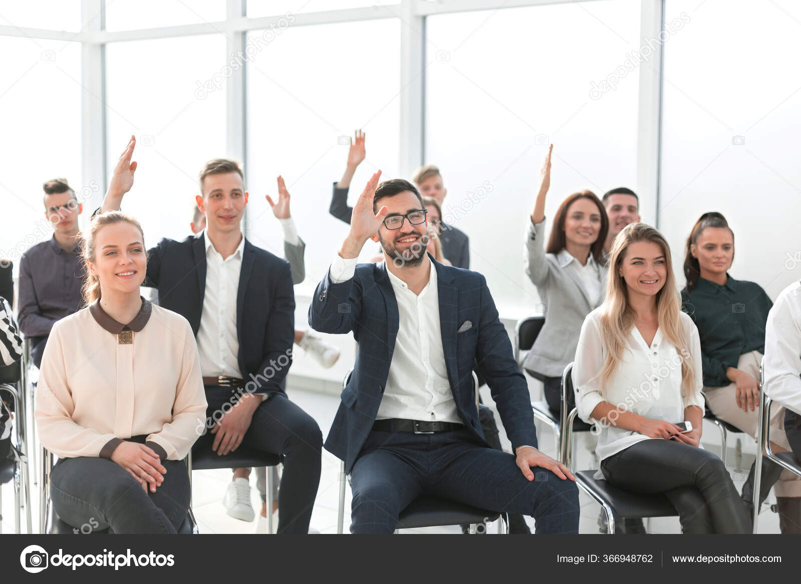 Personas levantando la mano en una sesión de preguntas